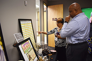 Plez Joyner, Deputy City Manager, and Leah Rodriguez, Admin Assistant, partake in Juneteenth displays