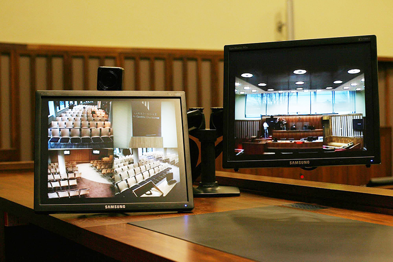 two digital screens showing a courtroom